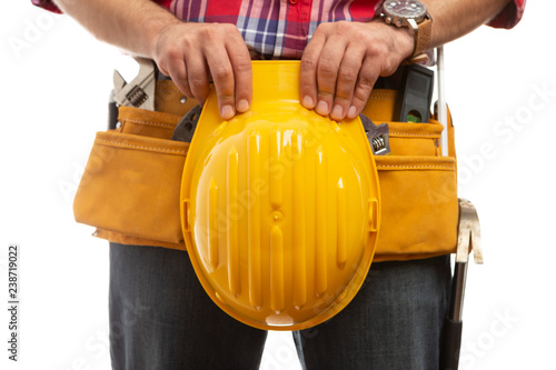 Builder holding hardhad over tool belt. photo