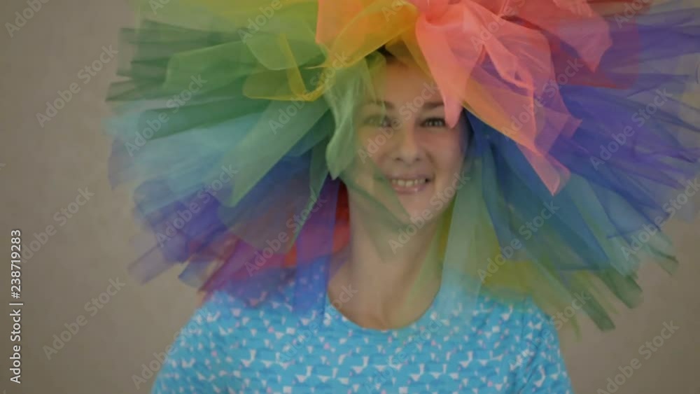 Disco girl dancing on party. Indoors portrait of amazing caucasian female model in trendy colorful wig woman with hair having fun smiling and dancing . Slow Motion. Disco girl dancing on party. Indoors portrait of amazing caucasian female model in trendy colorful wig woman with hair having fun smiling and dancing . Slow Motion.