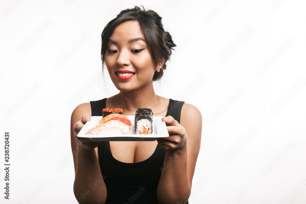 Beautiful young asian woman holding plate with sushi set