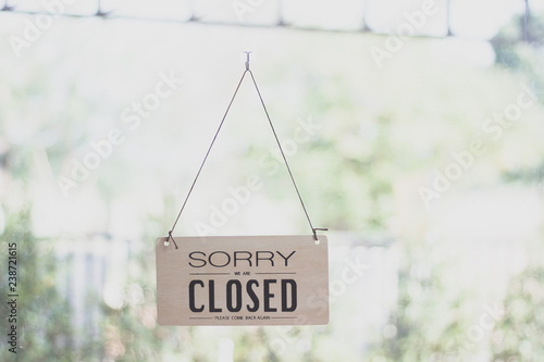A sign hanging off Coffee shop door,Close sign blur background,Label word close