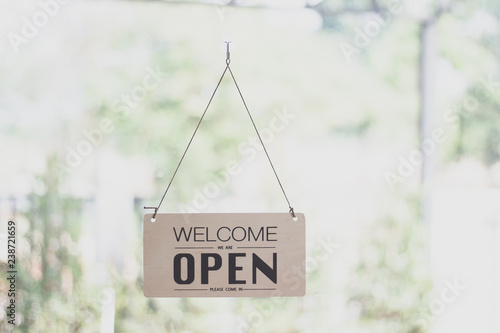 A sign hanging off Coffee shop door,Open sign blur background,Label word open