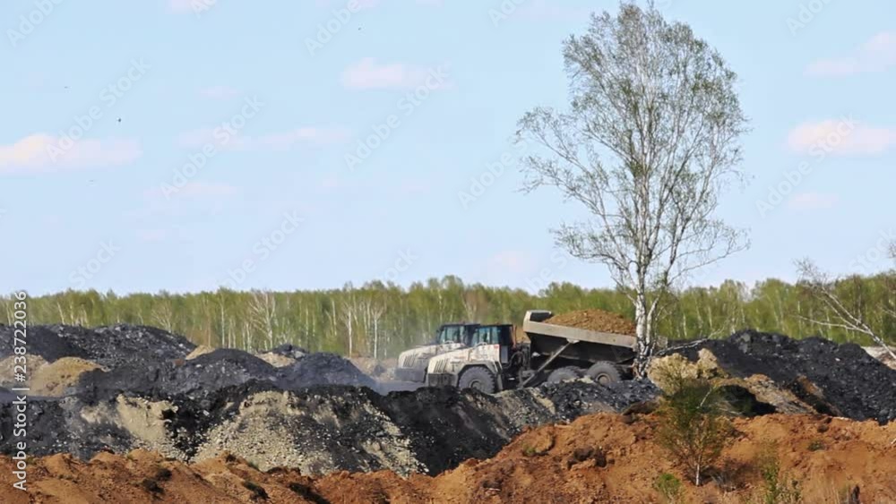 Mining truck dumps rock into a dump. Mining truck dumps rock into a dump.