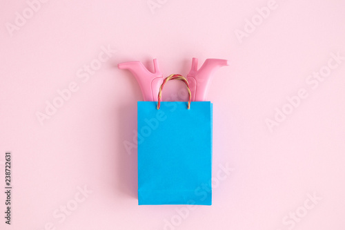 Flat lay of paper shopping bag with fashionable boots minimal creative concept.