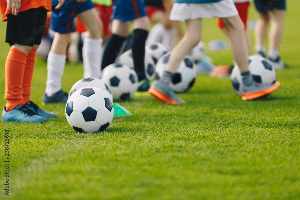 Football practice for youth. Children soccer training background. Group of young boys training soccer drills on green grass.