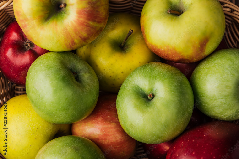 close up view of ripe multicolored apples in wicker basket close up view of ripe multicolored apples in wicker basket