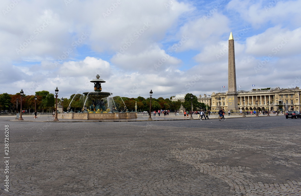 Paris, France, August 2018. La Concorde Square. Fountain, obelisk, street lights and tourists. Cloudy sky.