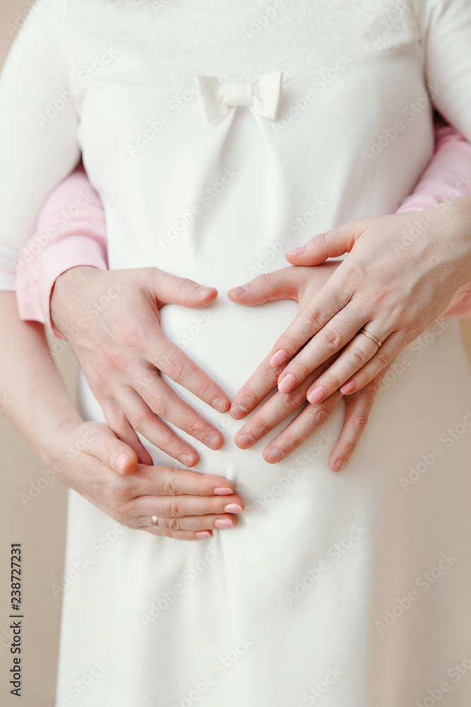 hands of future parents on a pregnant belly hands of future parents on a pregnant belly
