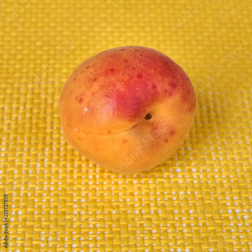 Fresh and delicious apricot fruits on yellow background photo