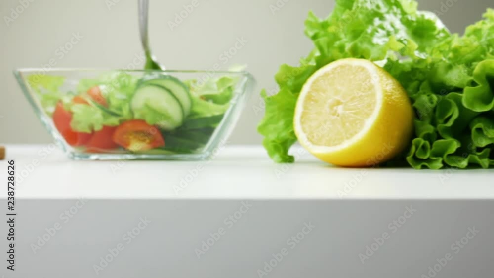 Healthy food. Vegetarian food. Ingredients for the salad on the table. Lettuce, cherry tomatoes, cucumber, red and yellow peppers, parsley. Glass bowl for salad. The camera moves from right to left Healthy food. Vegetarian food. Ingredients for the salad on the table. Lettuce, cherry tomatoes, cucumber, red and yellow peppers, parsley. Glass bowl for salad. The camera moves from right to left