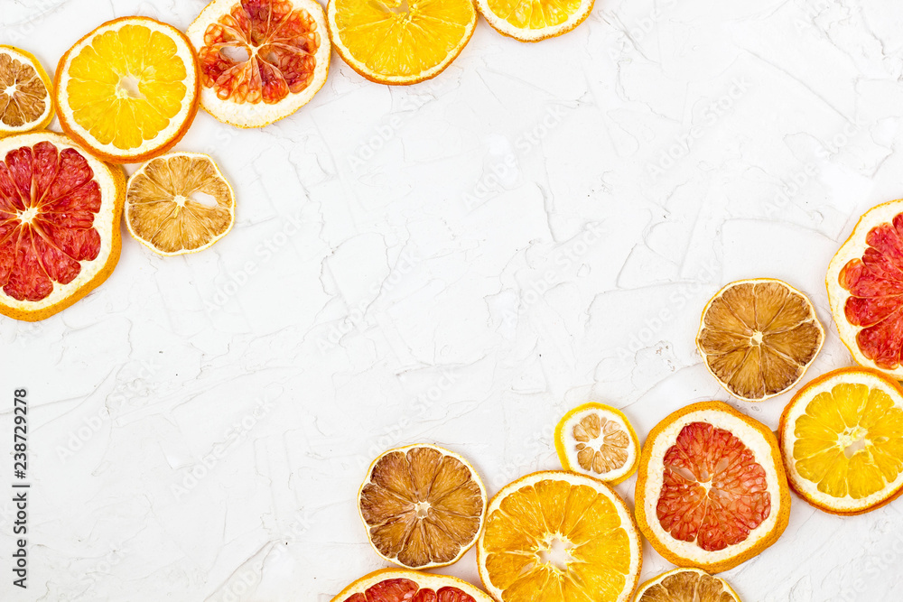 Naklejka Border of Dried slices of various citrus fruits on white background. Orange lemon grapefruit with copyspace