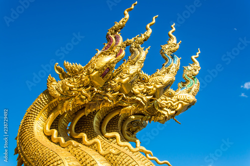 Golden Naga Statue with background sky