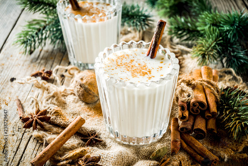 Classic Christmas drink Eggnog, chilean Cola de mono (monkey tail) cocktail, or Puerto Rican Coquito  eggnog, on old wooden background with pine tree branches copy spaces photo