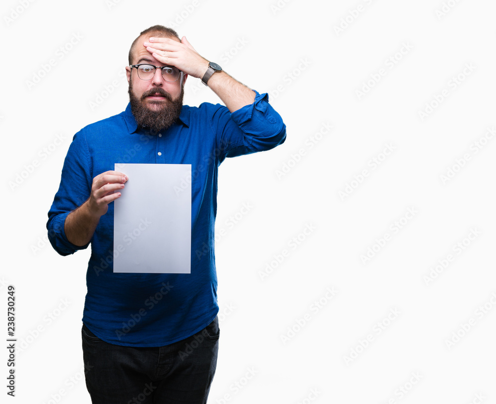 Young hipster man wearing glasses and holding blank paper over isolated background stressed with hand on head, shocked with shame and surprise face, angry and frustrated. Fear and upset for mistake. Young hipster man wearing glasses and holding blank paper over isolated background stressed with hand on head, shocked with shame and surprise face, angry and frustrated. Fear and upset for mistake.