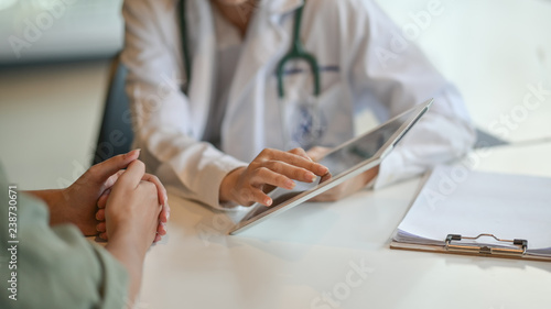 Obraz na plátně Shot of a doctor showing a patient some information on a digital tablet