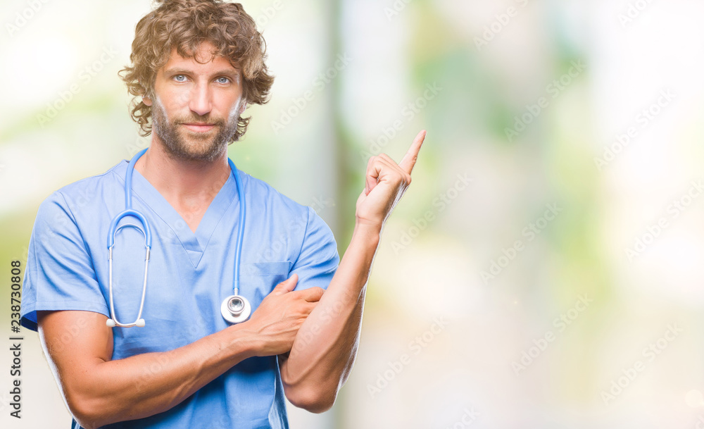 Handsome hispanic surgeon doctor man over isolated background with a big smile on face, pointing with hand and finger to the side looking at the camera.