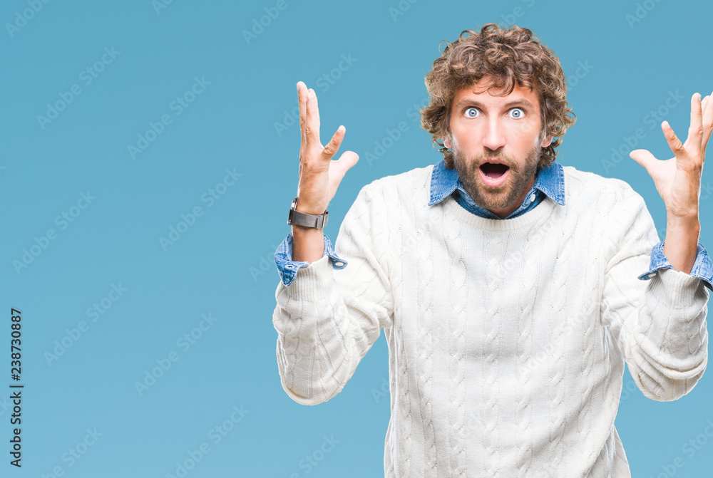 Handsome hispanic man model wearing winter sweater over isolated background celebrating crazy and amazed for success with arms raised and open eyes screaming excited. Winner concept Handsome hispanic man model wearing winter sweater over isolated background celebrating crazy and amazed for success with arms raised and open eyes screaming excited. Winner concept