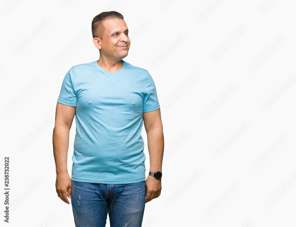 Middle age arab man wearing blue t-shirt over isolated background smiling looking side and staring away thinking. Middle age arab man wearing blue t-shirt over isolated background smiling looking side and staring away thinking.