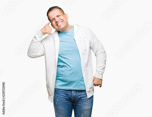 Middle age arab man wearing sweatshirt over isolated background smiling doing phone gesture with hand and fingers like talking on the telephone. Communicating concepts. © Krakenimages.com