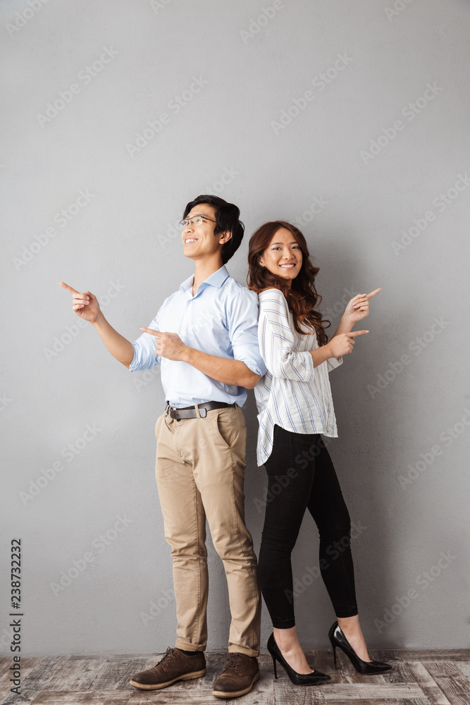 Fototapeta premium Full length of cheerful asian couple standing