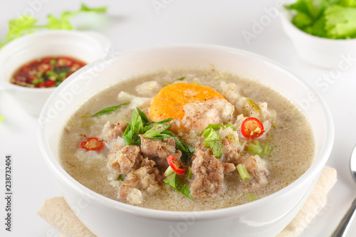 Congee with minced pork and boiled egg in bowl © Thanrada H.
