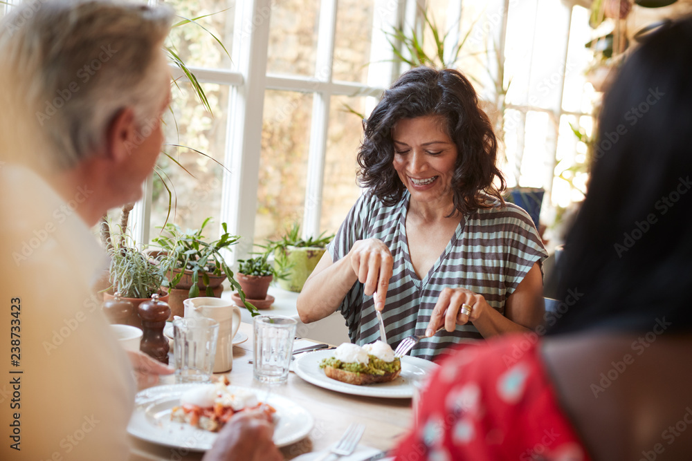 White adult woman eating with friends at a cafe, close up