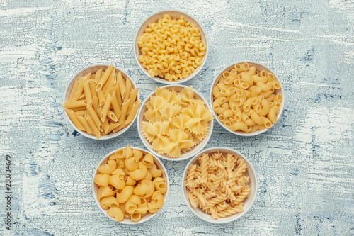 Different pasta types in bowls on the table.