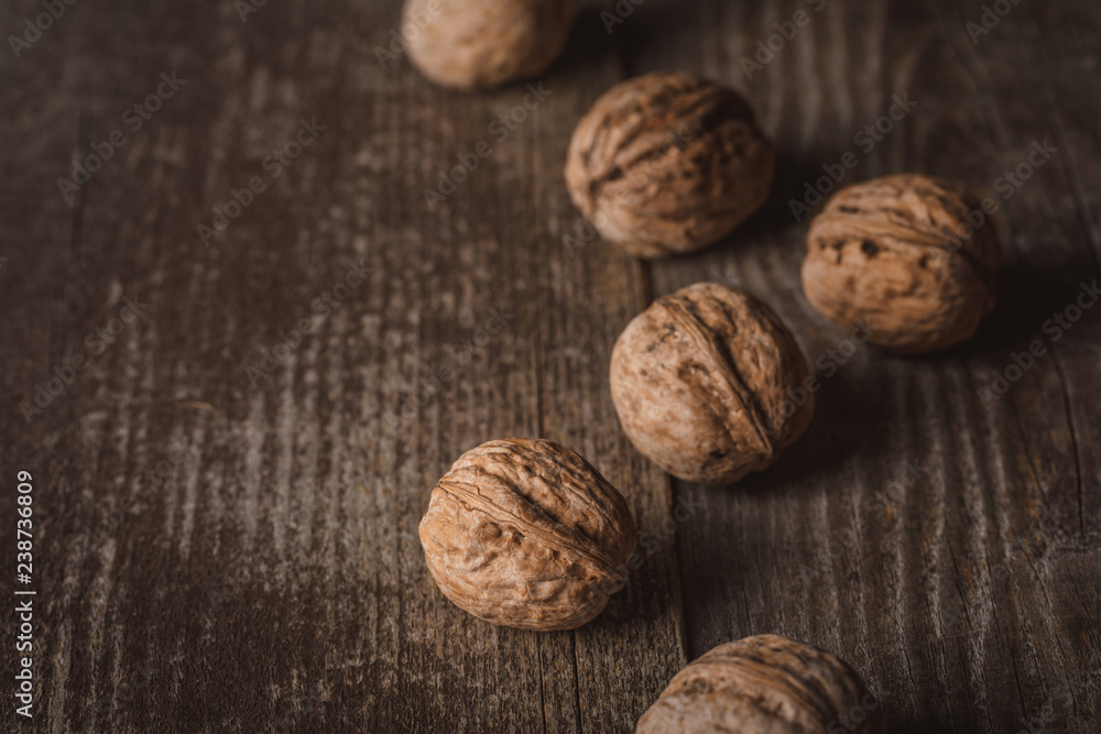 close up view of walnuts on wooden surface close up view of walnuts on wooden surface