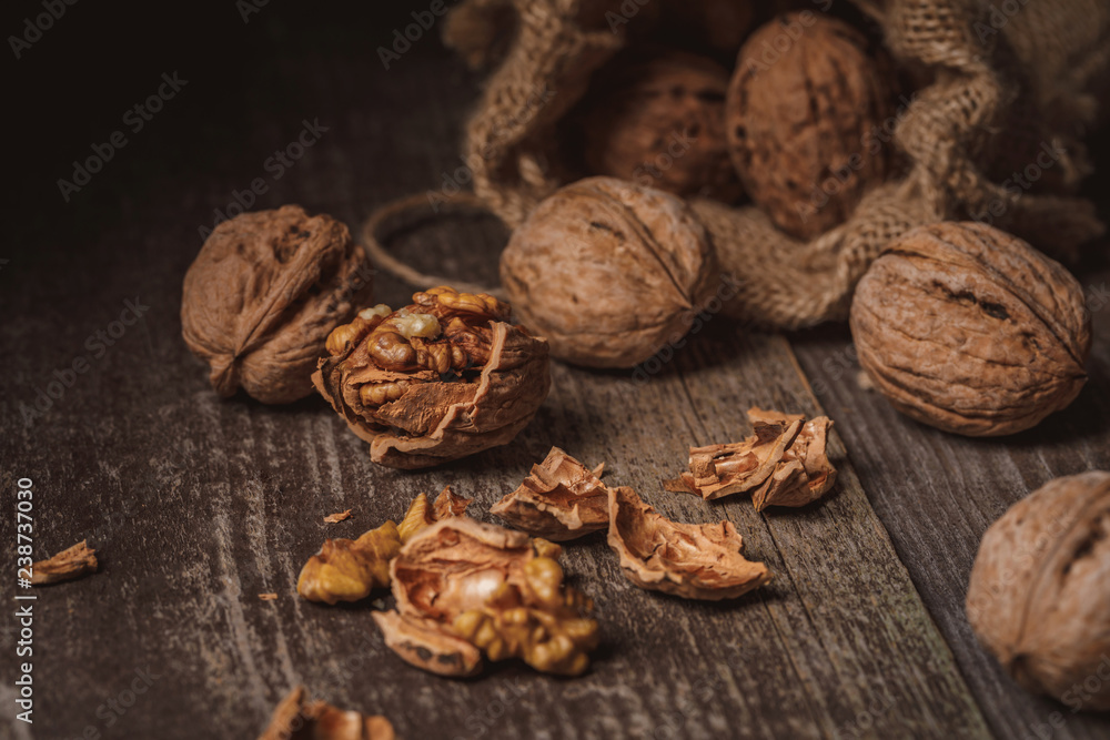 close up view of walnuts in sack on wooden background close up view of walnuts in sack on wooden background