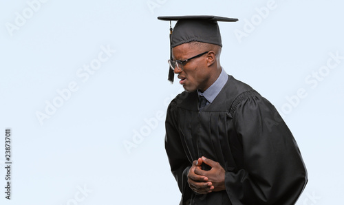 Young graduated african american man over isolated background with hand on stomach because nausea, painful disease feeling unwell. Ache concept.