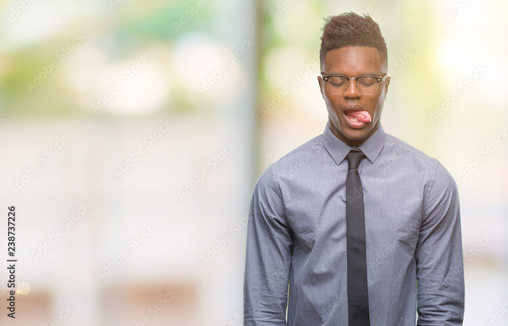 Young african american business man over isolated background sticking tongue out happy with funny expression. Emotion concept.