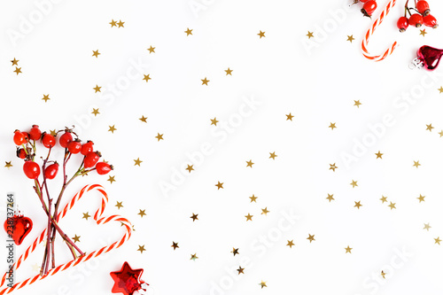 Fototapeta Naklejka Na Ścianę i Meble -  Christmas composition. Red rosehip berries on a white background and golden stars. Christmas, new year, winter concept. Flat lay, top view, copy space