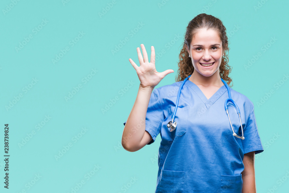 Young brunette doctor girl wearing nurse or surgeon uniform over isolated background showing and pointing up with fingers number five while smiling confident and happy. Young brunette doctor girl wearing nurse or surgeon uniform over isolated background showing and pointing up with fingers number five while smiling confident and happy.
