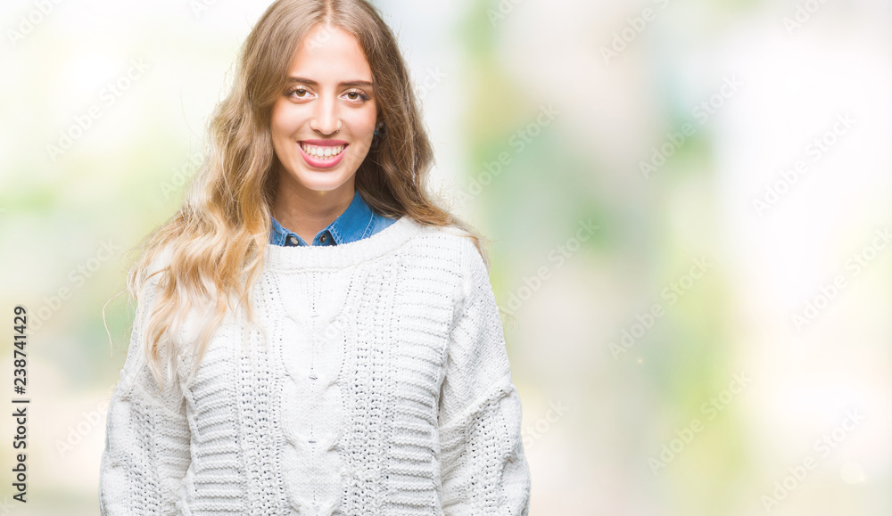 Beautiful young blonde woman wearing winter sweater over isolated background with a happy and cool smile on face. Lucky person. Beautiful young blonde woman wearing winter sweater over isolated background with a happy and cool smile on face. Lucky person.