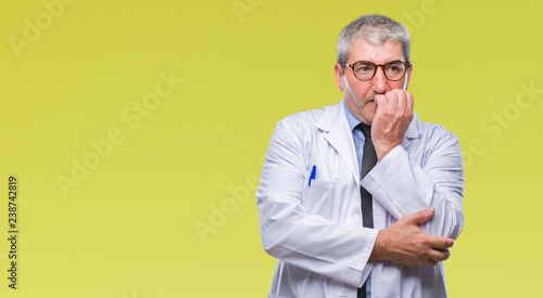 Handsome senior doctor, scientist professional man wearing white coat over isolated background looking stressed and nervous with hands on mouth biting nails. Anxiety problem. © Krakenimages.com