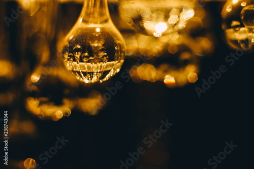  Blurred abstract background of crystal glowing spheres chandeliers. Warm light .