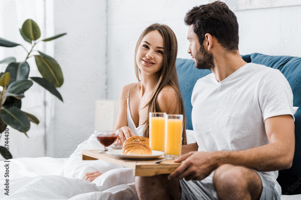 young couple having breakfast in bedroom