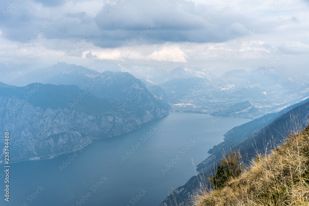 Breathtaking view of the lake garda and the mountain range with clouds  in the background, view to the north, to riva
