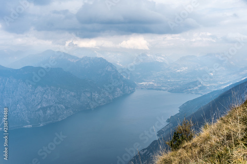 Breathtaking view of the lake garda and the mountain range with clouds in the background, view to the north, to riva 