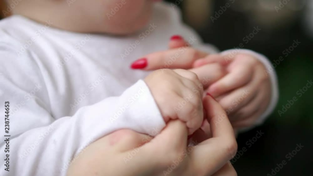 Caring mother with baby, Concept of love and family. hands of mother and baby closeup, Hand in hand. Mother care. Playing with baby at home. Slow Motion Caring mother with baby, Concept of love and family. hands of mother and baby closeup, Hand in hand. Mother care. Playing with baby at home. Slow Motion