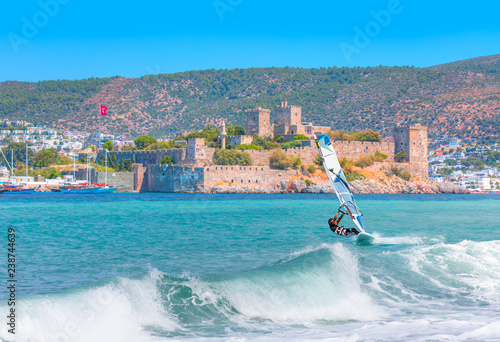 Fototapeta Naklejka Na Ścianę i Meble -  Saint Peter Castle (Bodrum castle) and marina in Bodrum, Turkey - Beautiful cloudy sky with Windsurfer Surfing The Wind On Waves