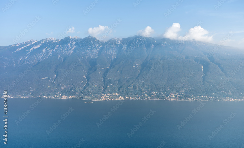 Breathtaking view of the lake garda and the mountain range with clouds  in the background
