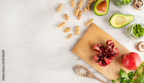 Cuisine, background of vegan food, avocado, pomegranate, green beans mushrooms, broccoli mushrooms, onions, nuts, greens. Clean and healthy food, detox, sports and diet on a white background