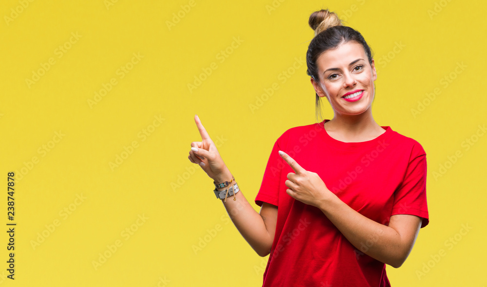 Young beautiful woman over isolated background smiling and looking at the camera pointing with two hands and fingers to the side. Young beautiful woman over isolated background smiling and looking at the camera pointing with two hands and fingers to the side.