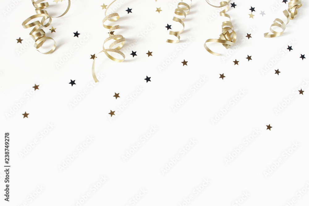 Happy New Year or birthday festive composition. Golden confetti and glittering stars on white table background. Celebration, party concept. Flat lay, top view. Empty copy space. - obrazy, fototapety, plakaty 