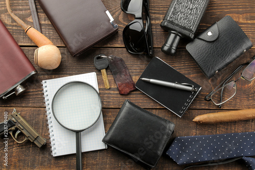 Men's Accessories. men's style. purse, flask, smoking pipe, perfume, business card holder, notebook, keys, glasses, cigar, on a brown wooden background. flat lay.