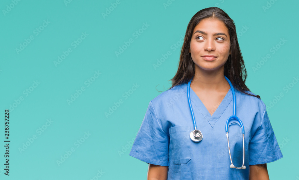 Young arab doctor surgeon woman over isolated background smiling looking side and staring away thinking. Young arab doctor surgeon woman over isolated background smiling looking side and staring away thinking.