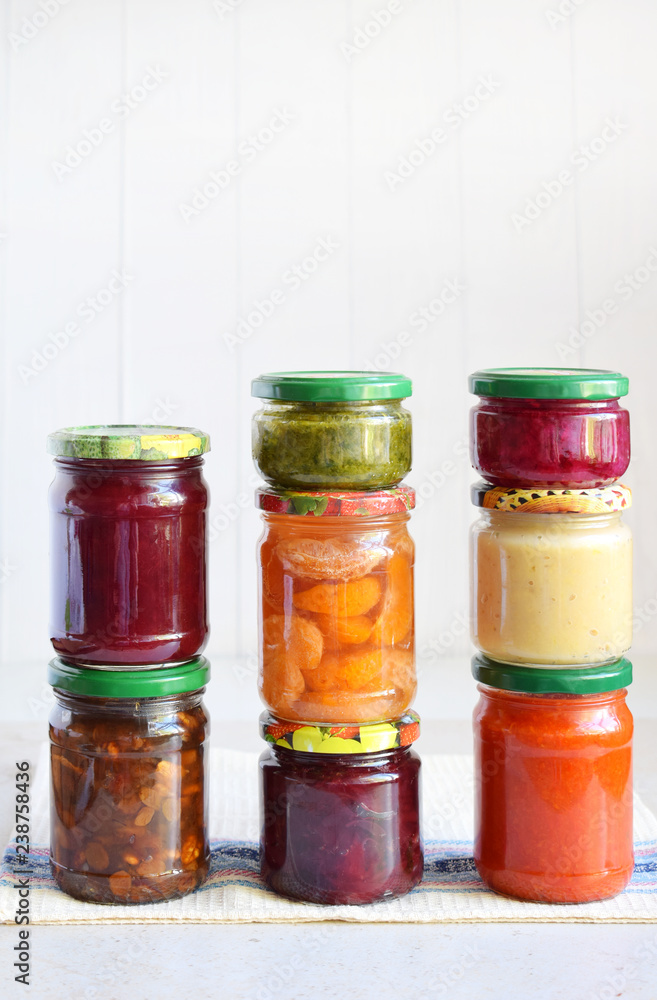 Variety of preserved food in glass jars - pickles, jam, marmalade, sauces, ketchup. Preserving vegetables and fruits. Fermented food. Autumn canning. Conservation of harvest Variety of preserved food in glass jars - pickles, jam, marmalade, sauces, ketchup. Preserving vegetables and fruits. Fermented food. Autumn canning. Conservation of harvest
