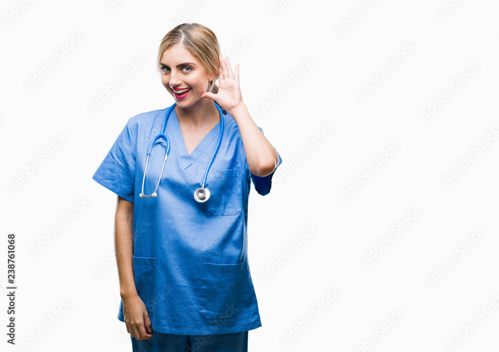 Young beautiful blonde doctor surgeon nurse woman over isolated background smiling with hand over ear listening an hearing to rumor or gossip. Deafness concept. Young beautiful blonde doctor surgeon nurse woman over isolated background smiling with hand over ear listening an hearing to rumor or gossip. Deafness concept.