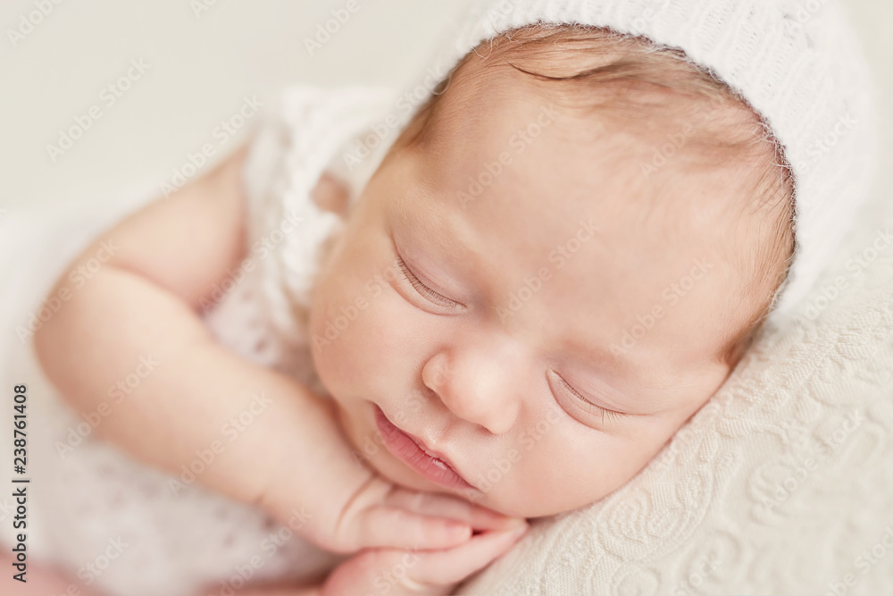 Cute newborn little girl sleeping on light background. Baby goods packaging template. Closeup portrait of newborn baby with smile on face. Healthy and medical concept. Eco conception. Nursery. Cute newborn little girl sleeping on light background. Baby goods packaging template. Closeup portrait of newborn baby with smile on face. Healthy and medical concept. Eco conception. Nursery.