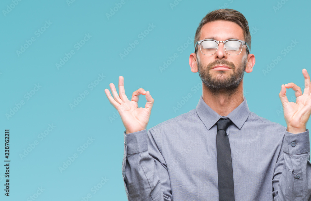 Young handsome business man over isolated background relax and smiling with eyes closed doing meditation gesture with fingers. Yoga concept. Young handsome business man over isolated background relax and smiling with eyes closed doing meditation gesture with fingers. Yoga concept.